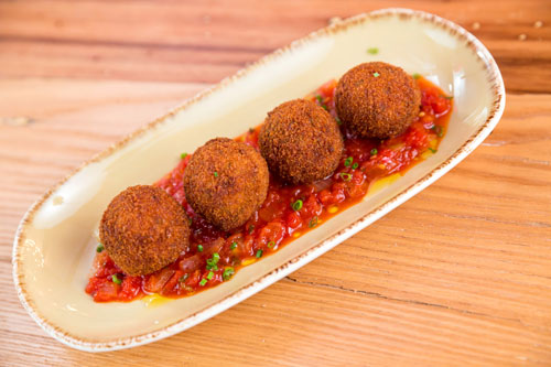 four balls of aranchini in red sauce